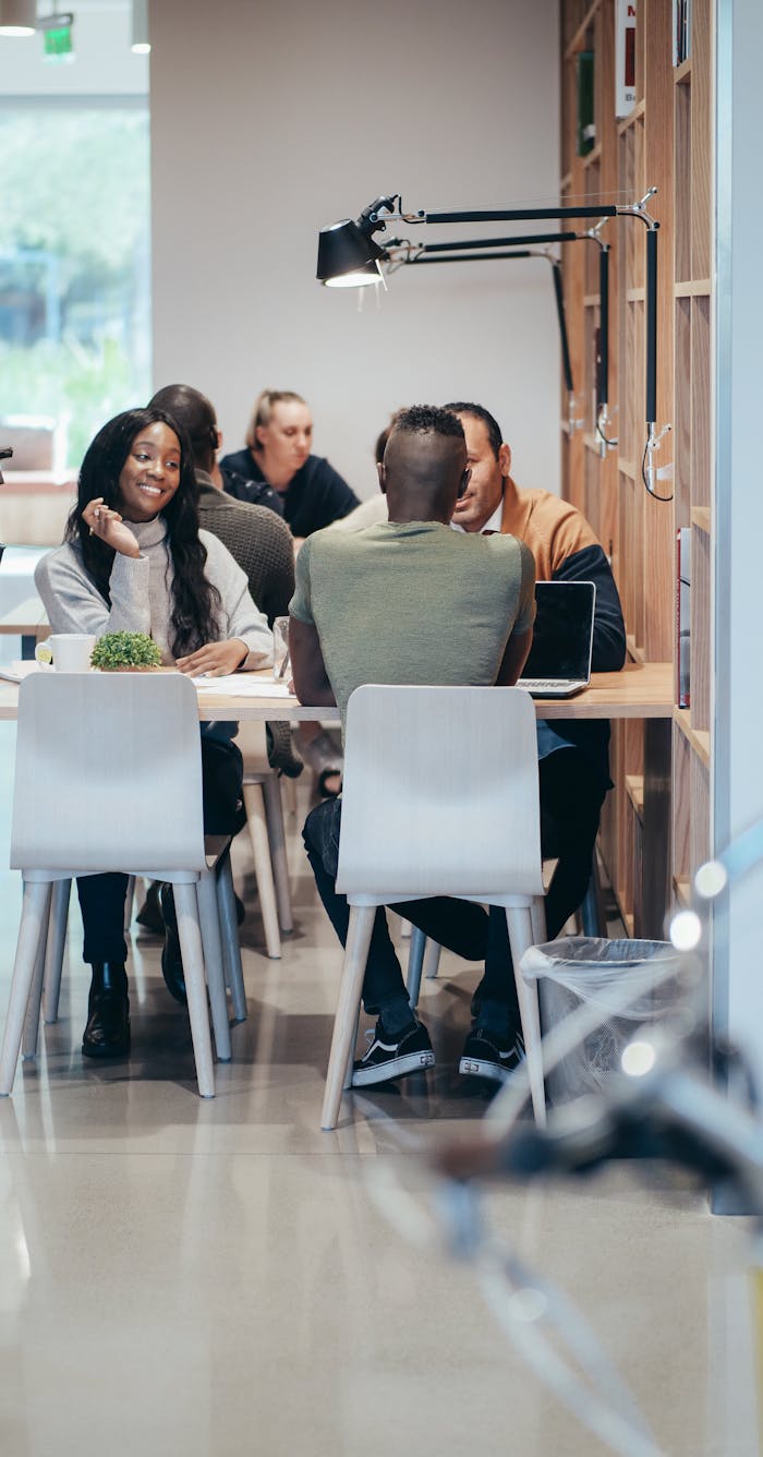 A diverse group of coworkers engaged in a meeting within a contemporary office setting.