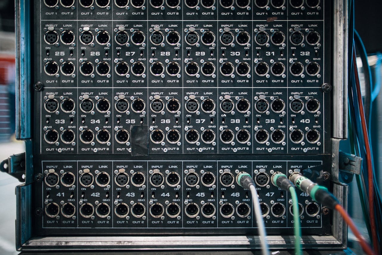Assorted wires with connectors in sockets of sound reinforcement system with numbers in row on stage